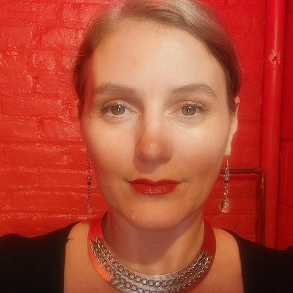 Image of woman against red background looking straight at camera.