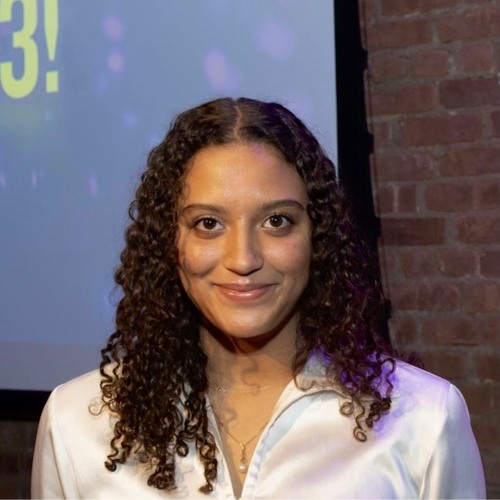 Photo of smiling woman, looking directly at camera. 